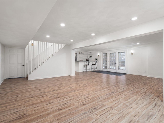 unfurnished living room featuring light wood-type flooring and french doors