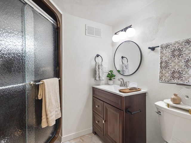 bathroom featuring toilet, vanity, tile patterned floors, and a shower with shower door