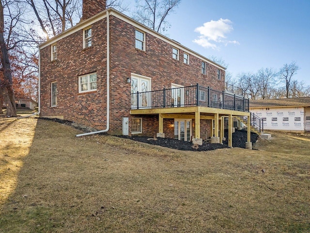 rear view of property featuring a deck and a lawn