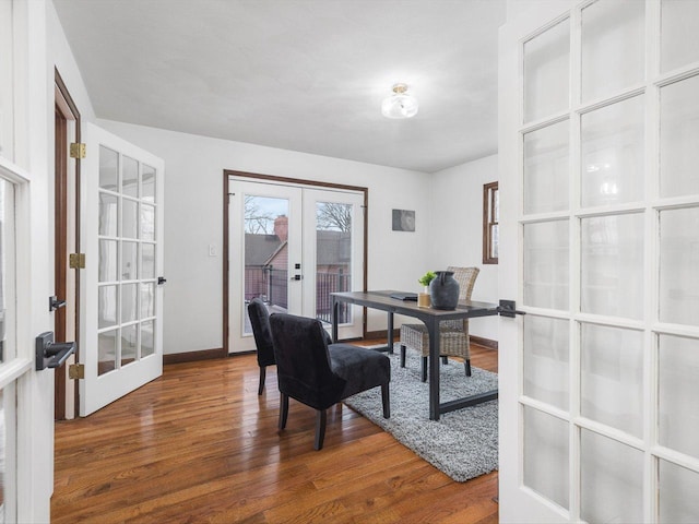 home office with dark hardwood / wood-style floors and french doors