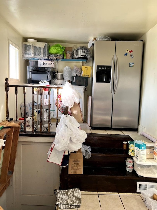 kitchen featuring stainless steel refrigerator with ice dispenser and light tile patterned floors