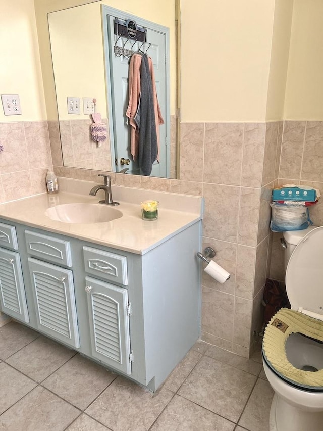 bathroom with tile patterned flooring, vanity, tile walls, and toilet