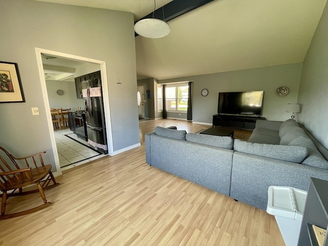 living room with light hardwood / wood-style floors and high vaulted ceiling