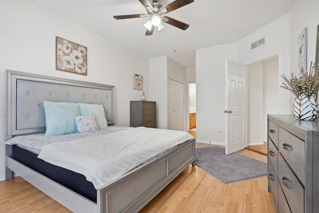 bedroom featuring ceiling fan, light hardwood / wood-style flooring, and a closet