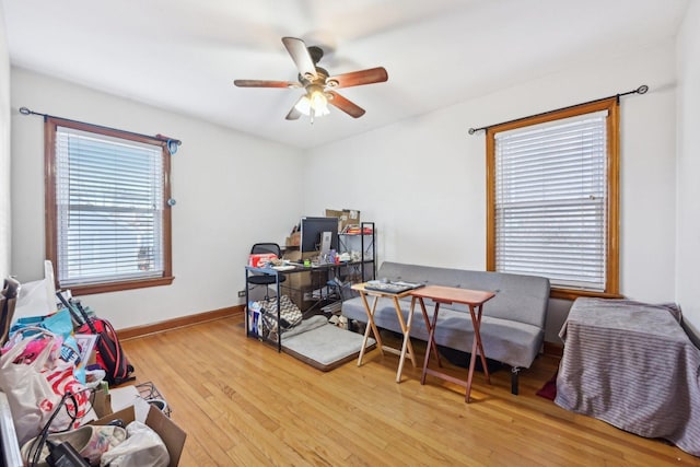 home office with light hardwood / wood-style flooring and ceiling fan