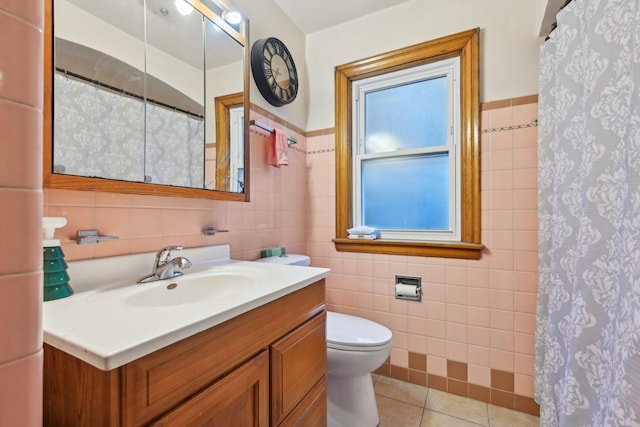 bathroom with toilet, tile walls, curtained shower, tile patterned flooring, and vanity