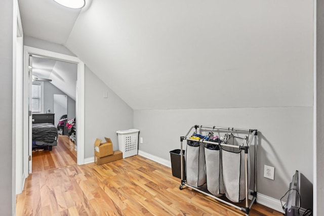 additional living space with light hardwood / wood-style flooring and lofted ceiling