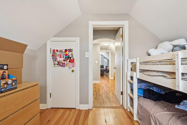 bedroom featuring light hardwood / wood-style floors and lofted ceiling