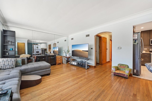 living room featuring light hardwood / wood-style flooring and crown molding