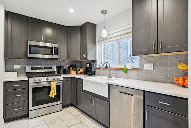 kitchen featuring decorative light fixtures, sink, appliances with stainless steel finishes, and tasteful backsplash