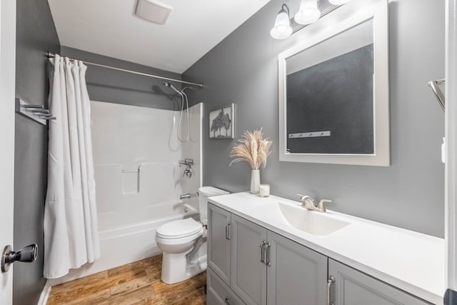 full bathroom with shower / bath combo with shower curtain, hardwood / wood-style flooring, toilet, and vanity