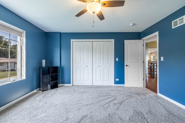 unfurnished bedroom with a closet, ceiling fan, and carpet floors