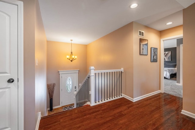 entryway with dark hardwood / wood-style flooring and an inviting chandelier