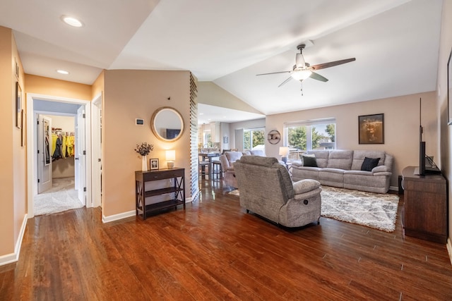 living room featuring vaulted ceiling, ceiling fan, and dark wood-type flooring