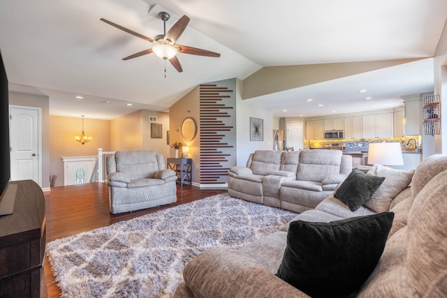 living room featuring ceiling fan with notable chandelier, hardwood / wood-style floors, and lofted ceiling