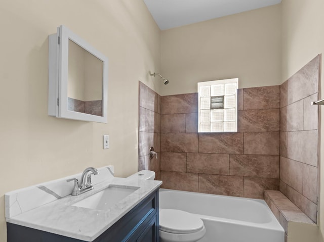 full bathroom featuring vanity, tiled shower / bath combo, and toilet