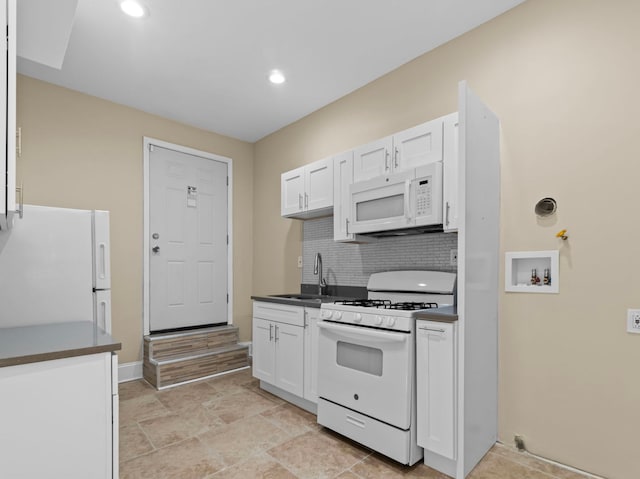 kitchen featuring white appliances, white cabinets, sink, and tasteful backsplash