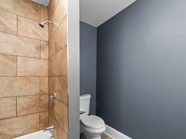 bathroom featuring toilet and tiled shower / bath combo