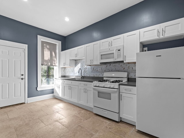 kitchen featuring sink, white appliances, white cabinetry, and tasteful backsplash