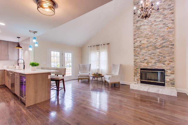 kitchen with a breakfast bar area, kitchen peninsula, pendant lighting, dark hardwood / wood-style flooring, and a fireplace