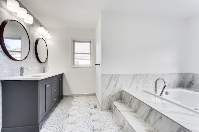 bathroom featuring vanity, tile patterned flooring, and a relaxing tiled tub