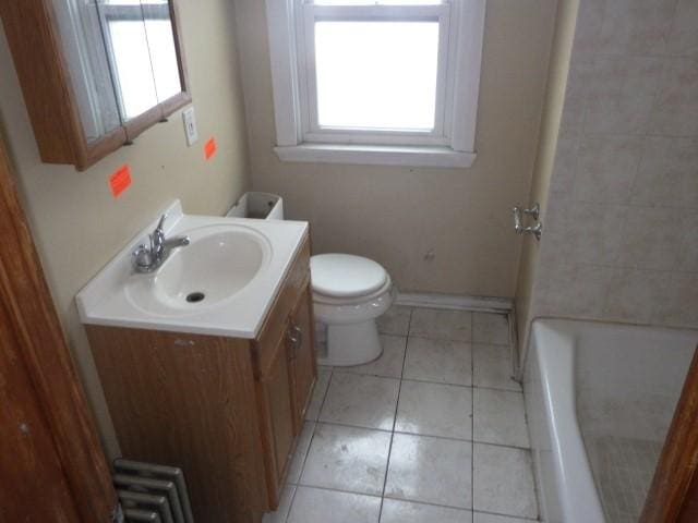 bathroom with vanity, a tub to relax in, tile patterned floors, and toilet