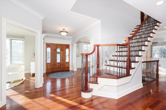 entrance foyer with dark hardwood / wood-style floors, ornate columns, and crown molding