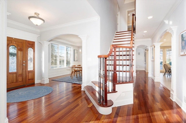 entryway featuring dark hardwood / wood-style flooring, ornate columns, and ornamental molding