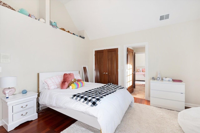 bedroom featuring wood-type flooring and high vaulted ceiling