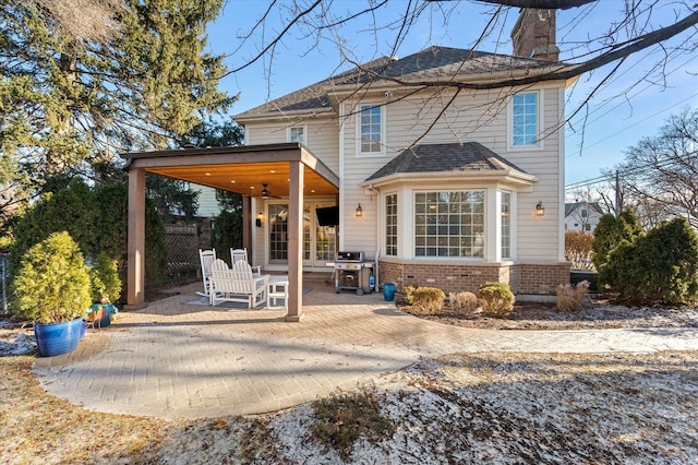 rear view of property featuring ceiling fan and a patio