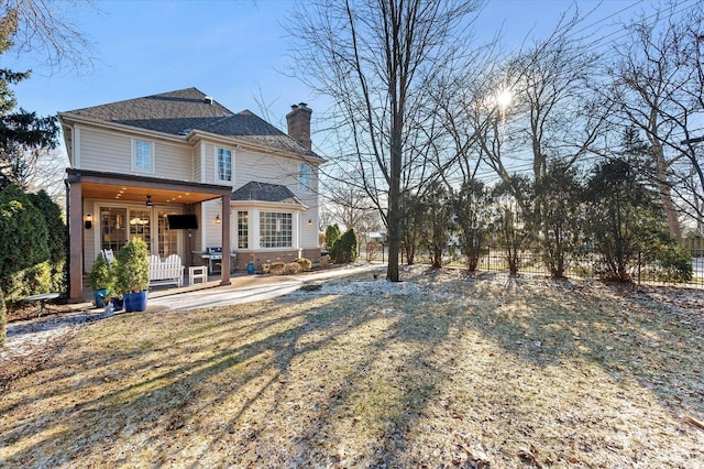 rear view of house featuring a lawn and a patio area