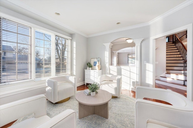 sitting room with ornate columns and crown molding