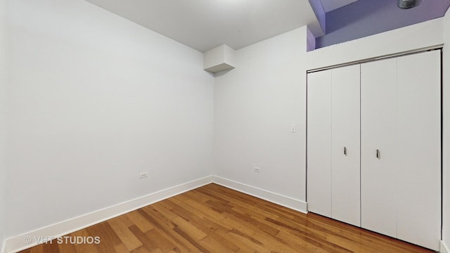 unfurnished bedroom with a closet and hardwood / wood-style floors