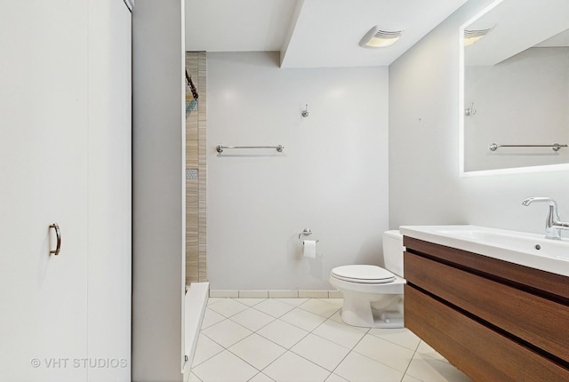 bathroom featuring toilet, tile patterned flooring, walk in shower, and vanity