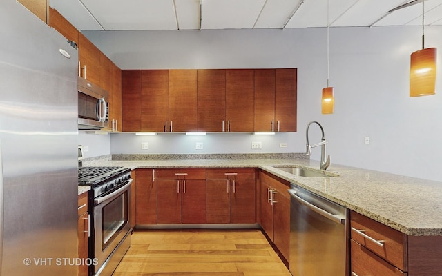 kitchen featuring appliances with stainless steel finishes, kitchen peninsula, and decorative light fixtures