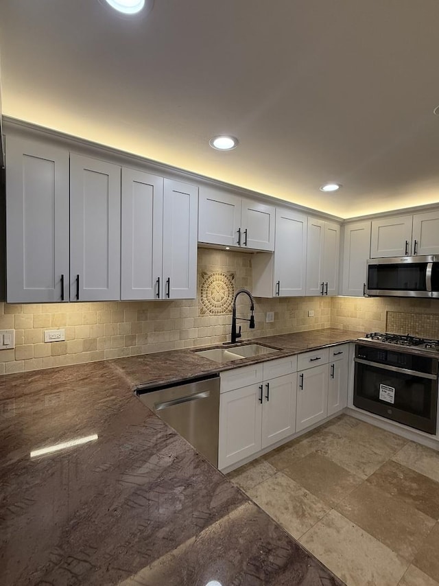 kitchen with white cabinetry, sink, decorative backsplash, and appliances with stainless steel finishes