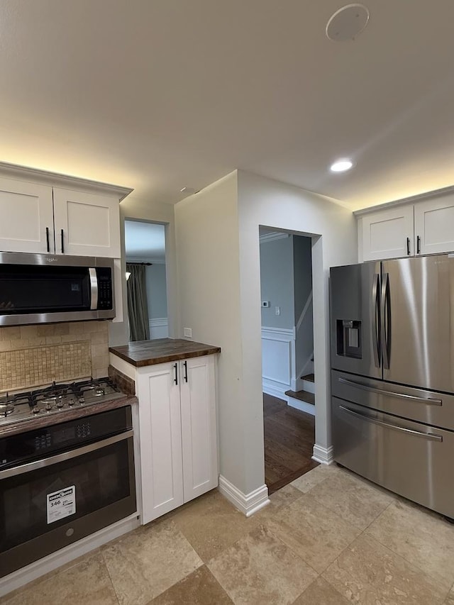 kitchen featuring white cabinetry, appliances with stainless steel finishes, and decorative backsplash