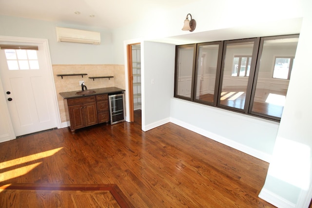 interior space with dark wood-type flooring, a wall mounted air conditioner, and beverage cooler