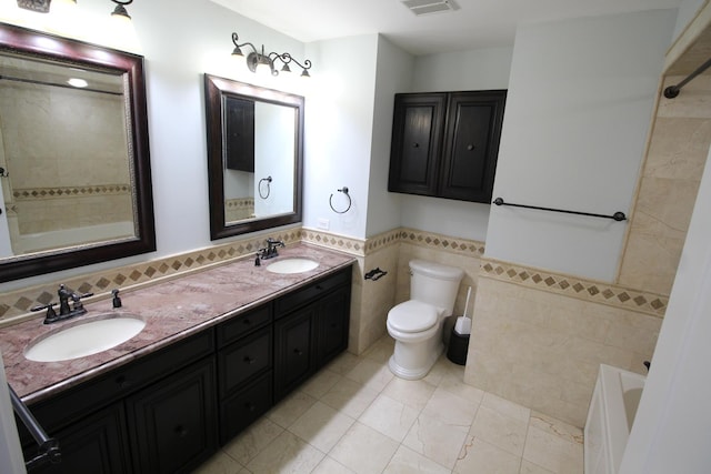 bathroom with tile walls, vanity, toilet, and a tub to relax in