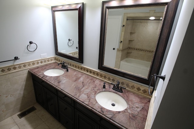 bathroom with tile walls, vanity, tile patterned floors, and shower / bathing tub combination