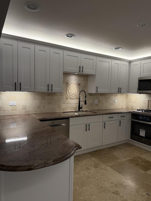 kitchen with white cabinetry, sink, wall oven, and decorative backsplash