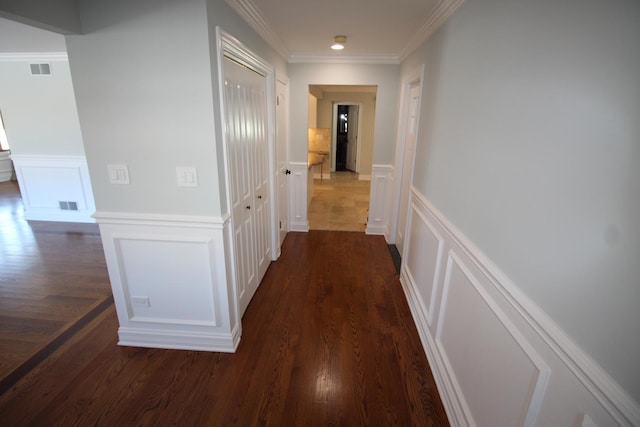 corridor with ornamental molding and dark hardwood / wood-style flooring