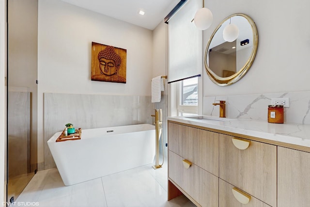 bathroom with tile patterned flooring, a bath, and vanity