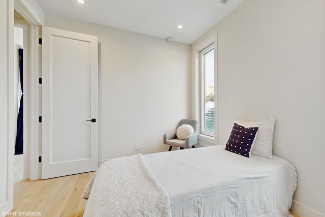 bedroom with multiple windows and light wood-type flooring