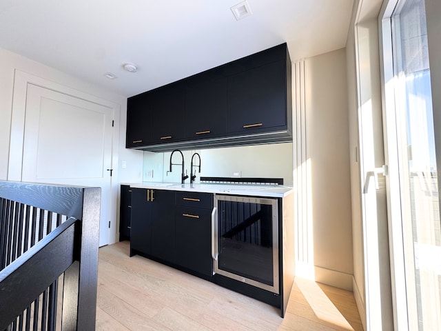 kitchen with light wood-type flooring and wine cooler