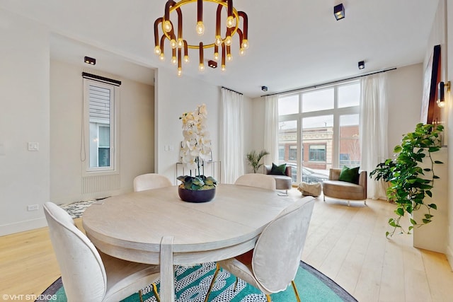 dining room featuring an inviting chandelier, light hardwood / wood-style flooring, and plenty of natural light