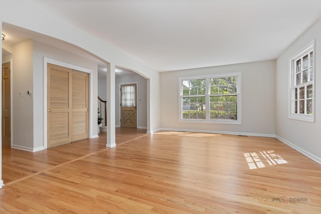 1712 Shawnee Trl, Northbrook, IL 60062 - unfurnished bedroom with arched walkways, light wood finished floors, and baseboards