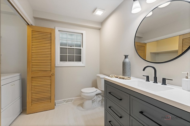 1712 Shawnee Trl, Northbrook, IL 60062 - bathroom with washer / clothes dryer, toilet, vanity, baseboards, and tile patterned flooring