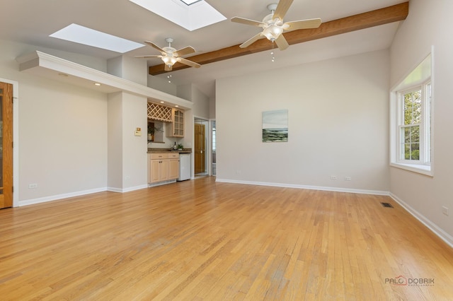1712 Shawnee Trl, Northbrook, IL 60062 - unfurnished living room featuring a skylight, ceiling fan, light wood-style flooring, and baseboards