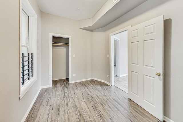 unfurnished bedroom with a closet and light hardwood / wood-style flooring